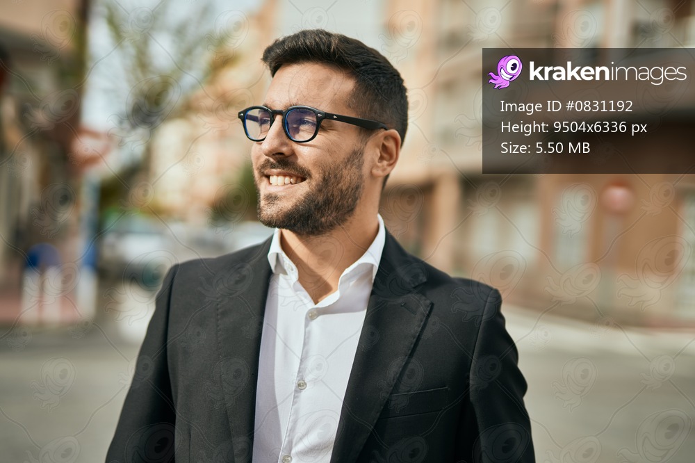Young hispanic businessman smiling happy standing at the city.