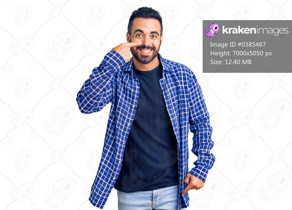 Young hispanic man wearing casual clothes pointing with hand finger to face and nose, smiling cheerful. beauty concept 