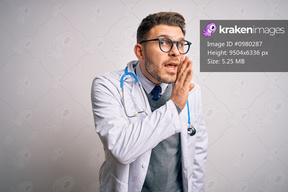 Young doctor man with blue eyes wearing medical coat and stethoscope over isolated background hand on mouth telling secret rumor, whispering malicious talk conversation