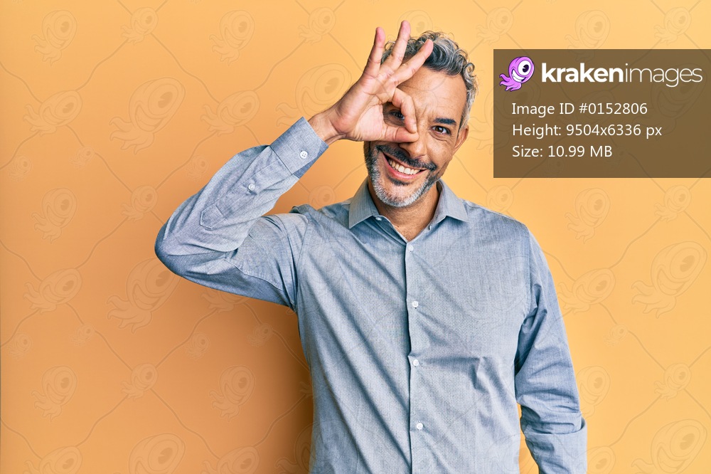 Middle age grey-haired man wearing casual clothes smiling happy doing ok sign with hand on eye looking through fingers 
