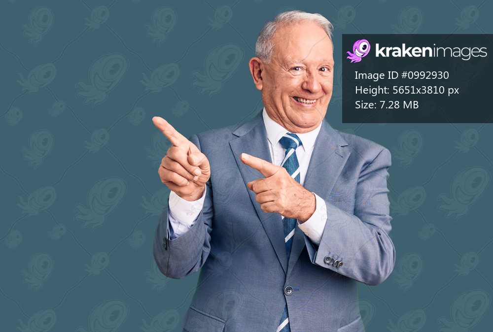 Senior handsome grey-haired man wearing elegant suit smiling and looking at the camera pointing with two hands and fingers to the side. 