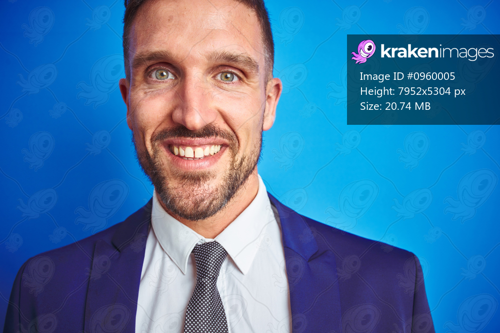 Close up picture of young handsome business man over blue isolated background with a happy and cool smile on face. Lucky person.