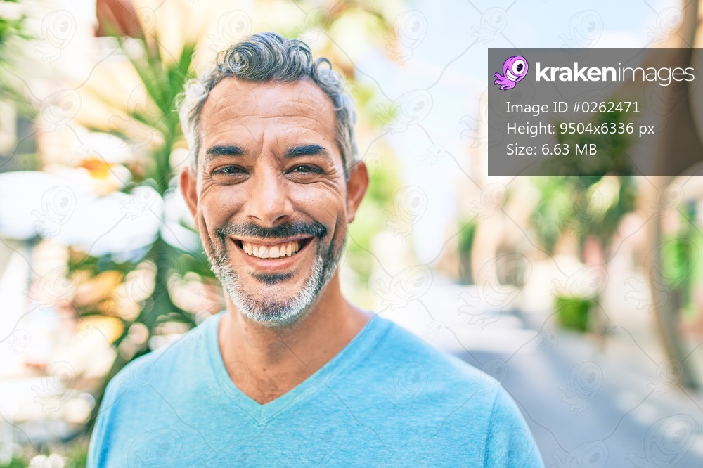 Middle age grey-haired man smiling happy walking at street of city.