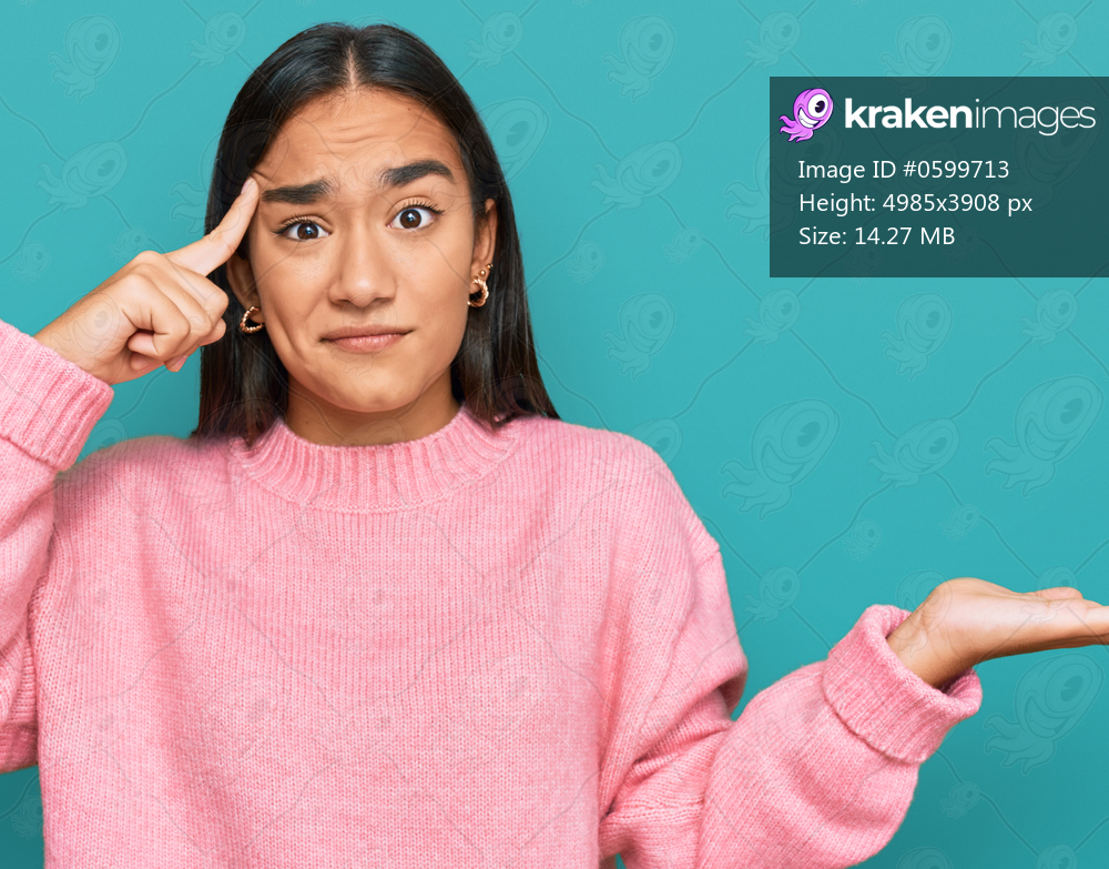 Young asian woman wearing casual winter sweater confused and annoyed with open palm showing copy space and pointing finger to forehead. think about it. 