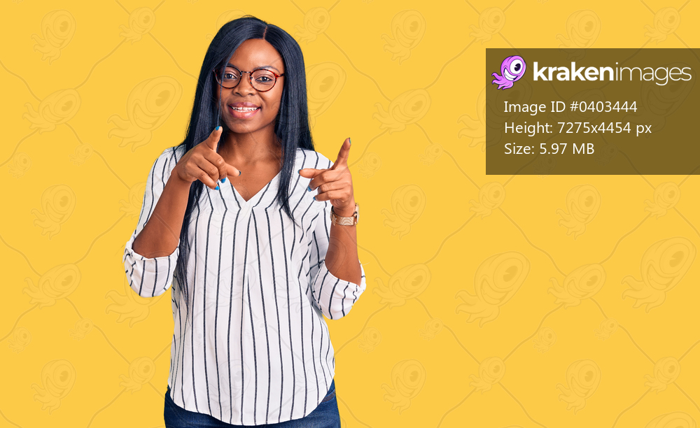Young african american woman wearing casual clothes and glasses pointing fingers to camera with happy and funny face. good energy and vibes. 