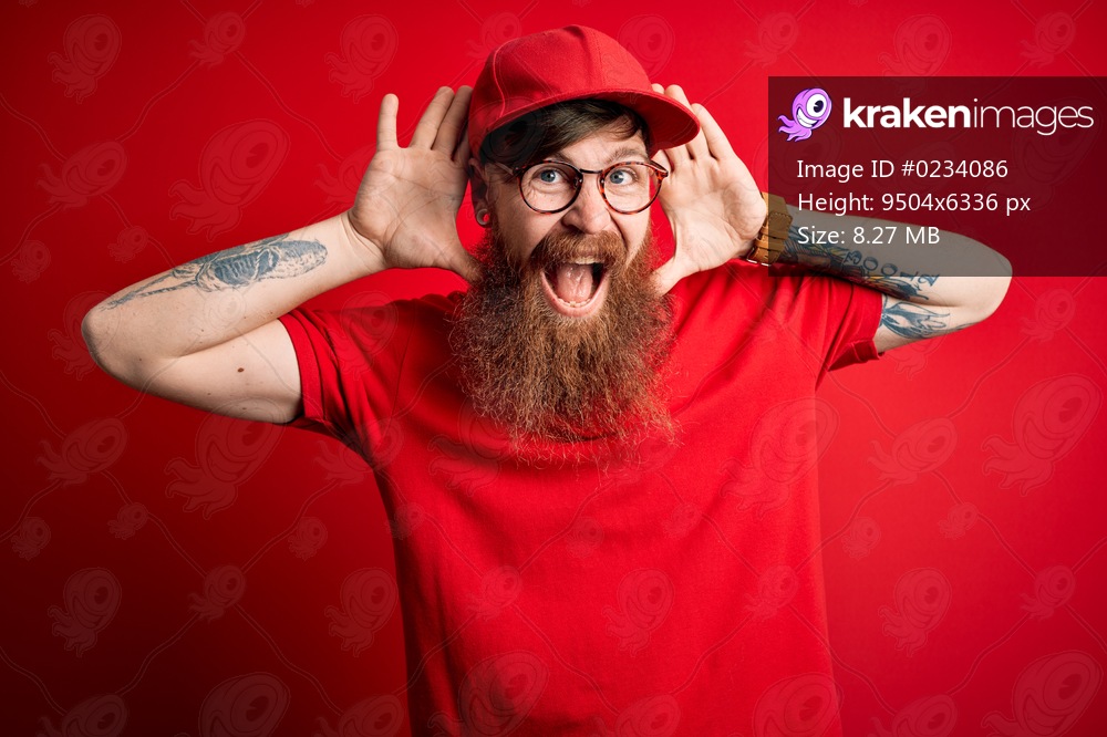 Young handsome delivery man wearing glasses and red cap over isolated background Smiling cheerful playing peek a boo with hands showing face. Surprised and exited