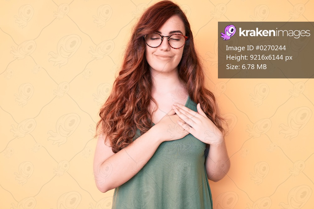 Young beautiful woman wearing casual clothes and glasses smiling with hands on chest with closed eyes and grateful gesture on face. health concept. 