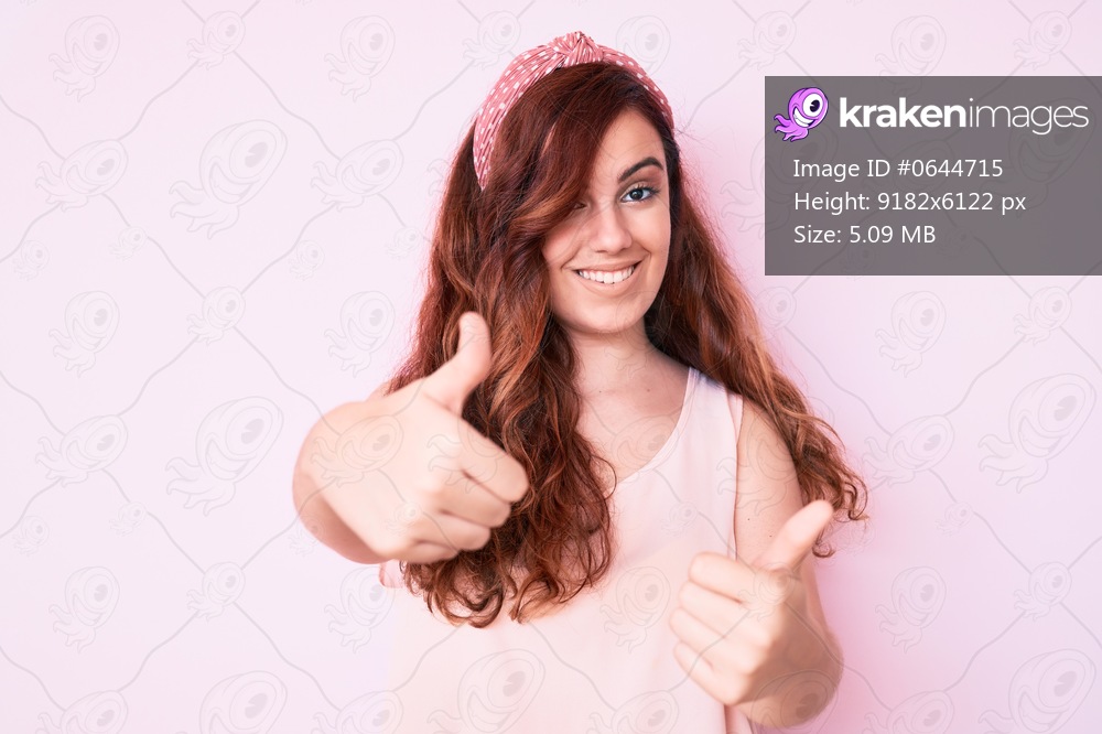 Young beautiful woman wearing casual clothes approving doing positive gesture with hand, thumbs up smiling and happy for success. winner gesture. 