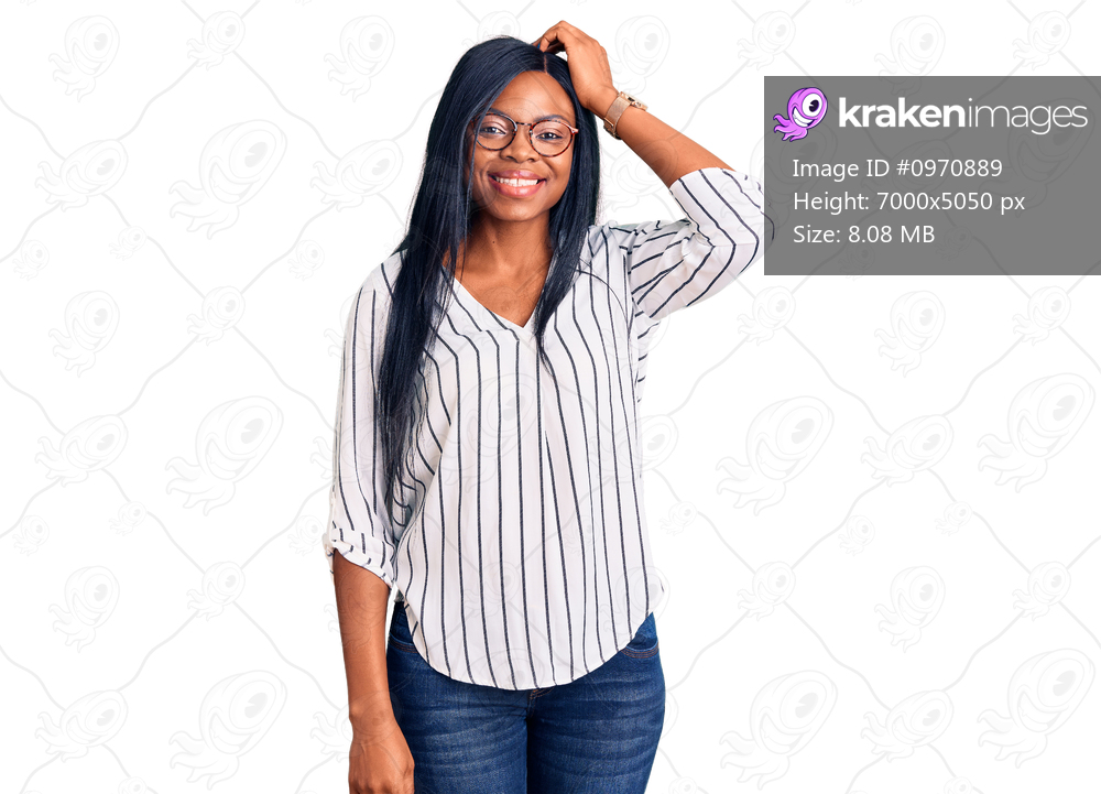 Young african american woman wearing casual clothes and glasses smiling confident touching hair with hand up gesture, posing attractive and fashionable 