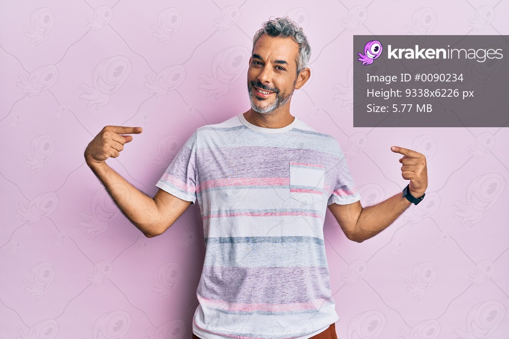 Middle age grey-haired man wearing casual clothes looking confident with smile on face, pointing oneself with fingers proud and happy. 