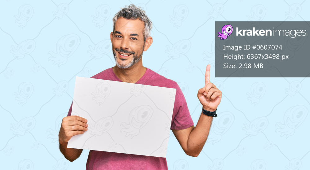 Middle age grey-haired man holding blank empty banner surprised with an idea or question pointing finger with happy face, number one 