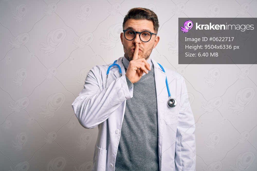 Young doctor man with blue eyes wearing medical coat and stethoscope over isolated background asking to be quiet with finger on lips. Silence and secret concept.