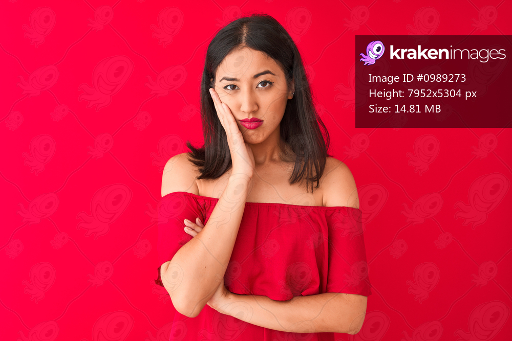 Young beautiful chinese woman wearing casual t-shirt standing over isolated red background thinking looking tired and bored with depression problems with crossed arms.