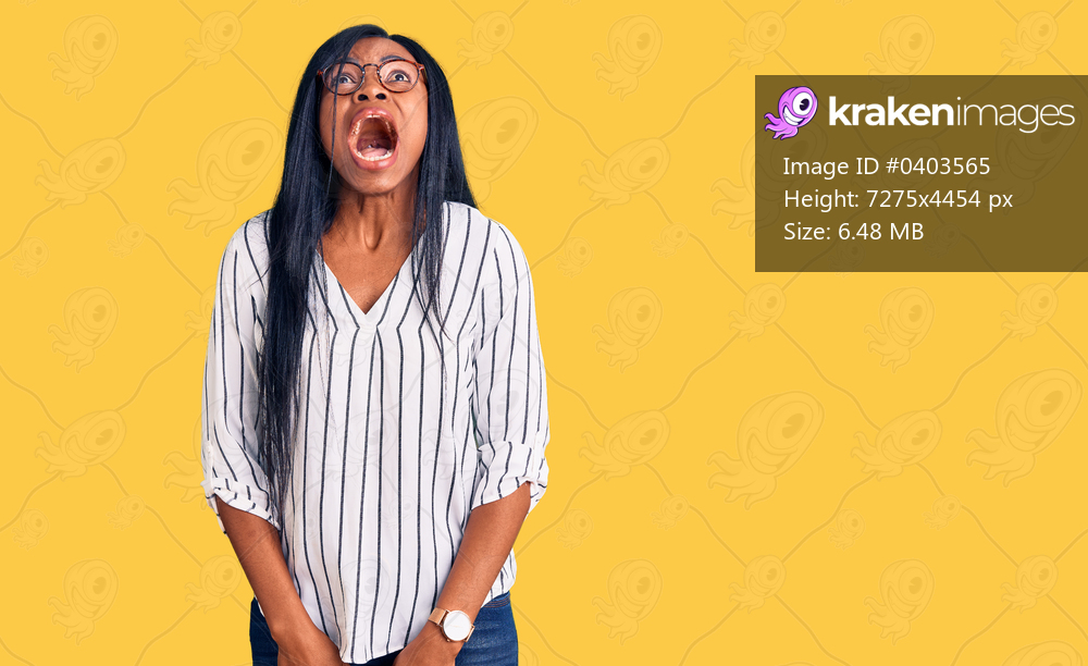 Young african american woman wearing casual clothes and glasses angry and mad screaming frustrated and furious, shouting with anger. rage and aggressive concept. 
