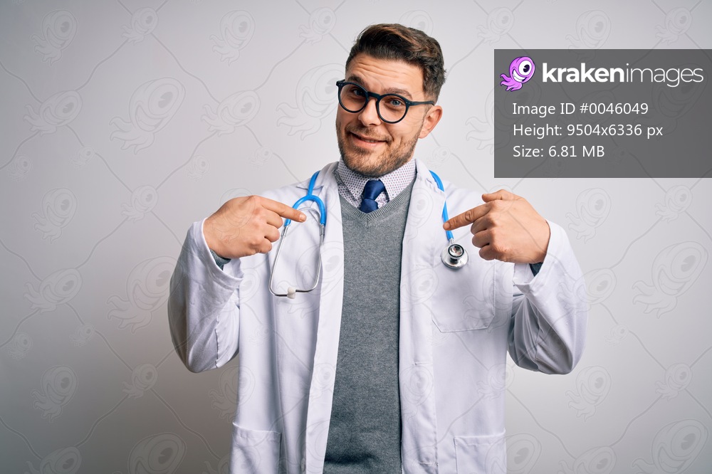 Young doctor man with blue eyes wearing medical coat and stethoscope over isolated background looking confident with smile on face, pointing oneself with fingers proud and happy.