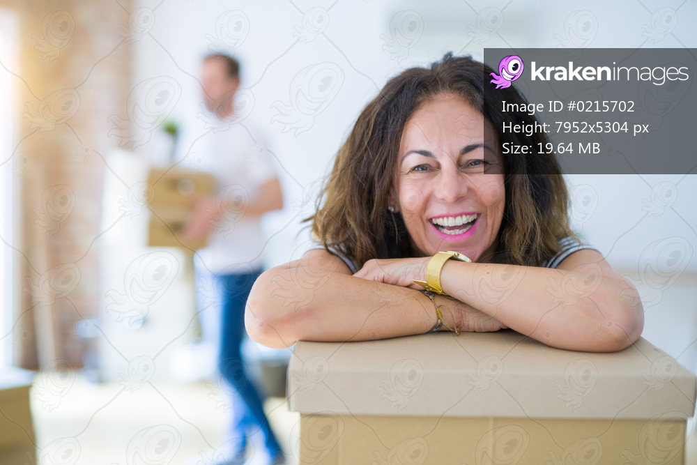 Middle age senior couple moving to a new house, woman smiling happy in love with new apartment