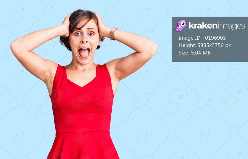 Beautiful young woman with short hair wearing casual style with sleeveless shirt crazy and scared with hands on head, afraid and surprised of shock with open mouth 