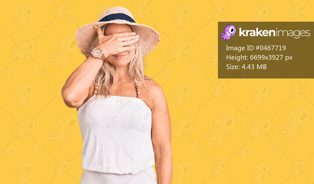 Middle age fit blonde woman wearing summer hat smiling and laughing with hand on face covering eyes for surprise. blind concept. 