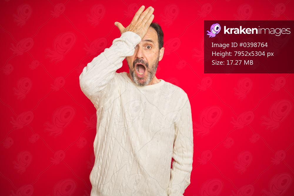 Handsome middle age senior man with grey hair over isolated red background surprised with hand on head for mistake, remember error. Forgot, bad memory concept.