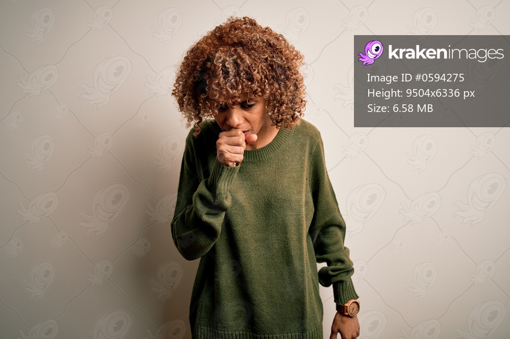 Beautiful african american woman with curly hair wearing casual sweater over white background feeling unwell and coughing as symptom for cold or bronchitis. Health care concept.