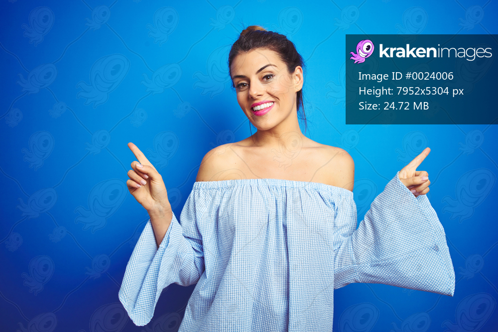 Young beautiful woman wearing bun hairstyle over blue isolated background smiling confident pointing with fingers to different directions. Copy space for advertisement