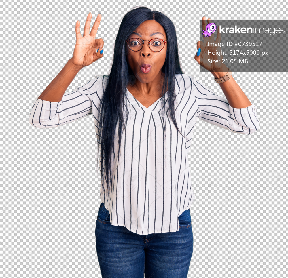Young african american woman wearing casual clothes and glasses looking surprised and shocked doing ok approval symbol with fingers. crazy expression