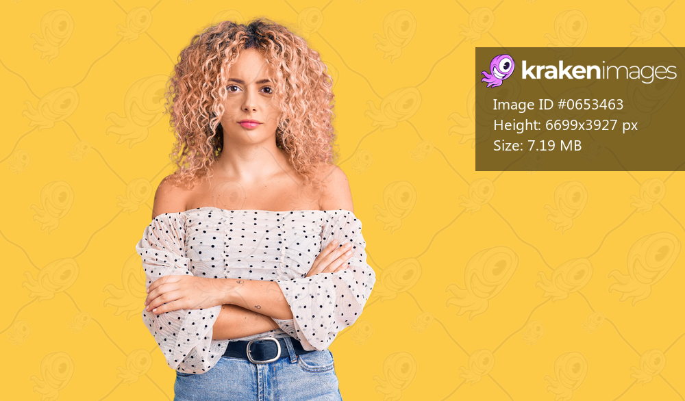 Young blonde woman with curly hair wearing casual clothes skeptic and nervous, disapproving expression on face with crossed arms. negative person. 