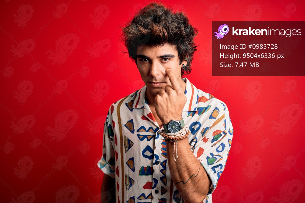 Young handsome man on vacation wearing summer shirt over isolated red background Pointing to the eye watching you gesture, suspicious expression