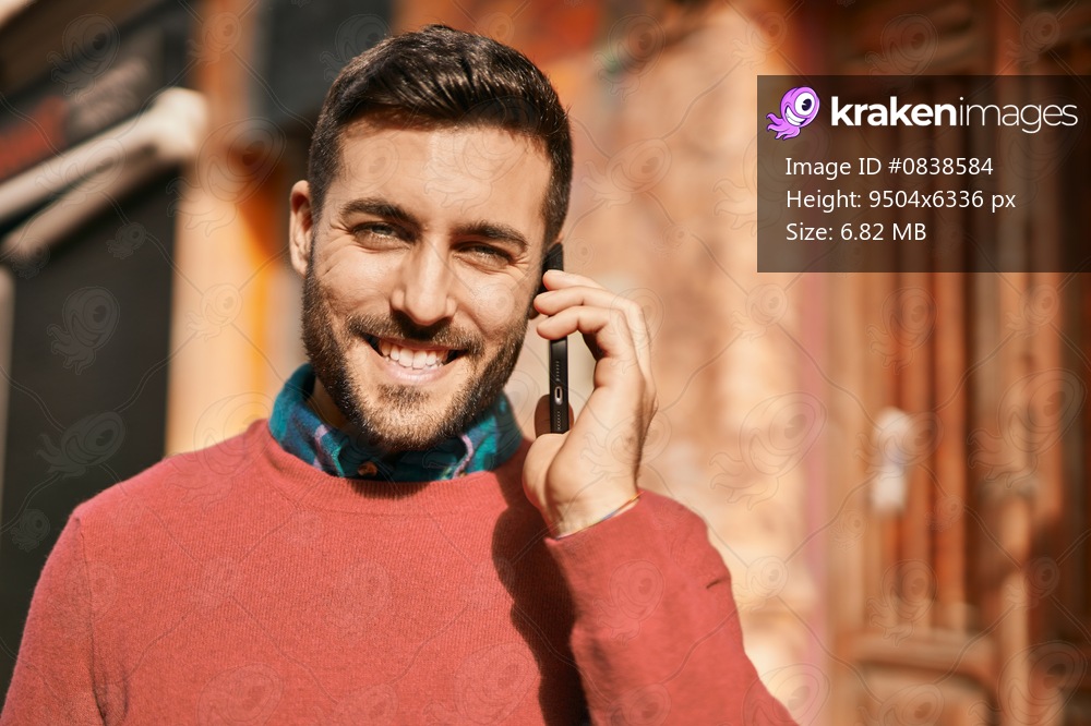 Young hispanic man smiling happy talking on the smartphone at the city.