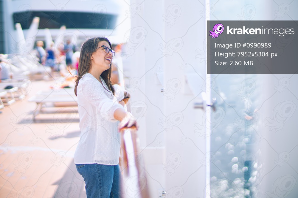 Young beautiful woman on vacation smiling happy and confident. Standing on a deck of ship with smile on face doing a cruise