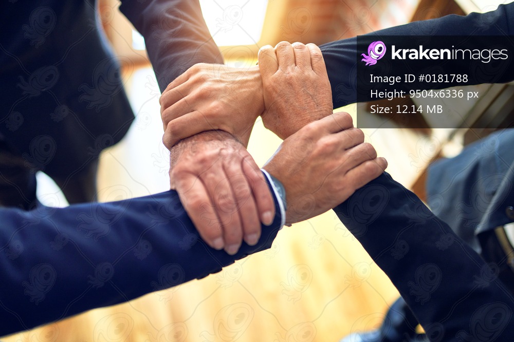 Group of business workers standing on a circle doing symbol with hands and arms together at the office.