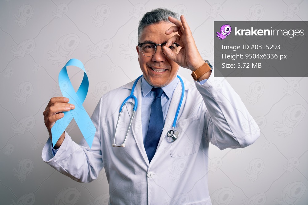 Middle age handsome grey-haired doctor man wearing coat holding blue cancer ribbon with happy face smiling doing ok sign with hand on eye looking through fingers