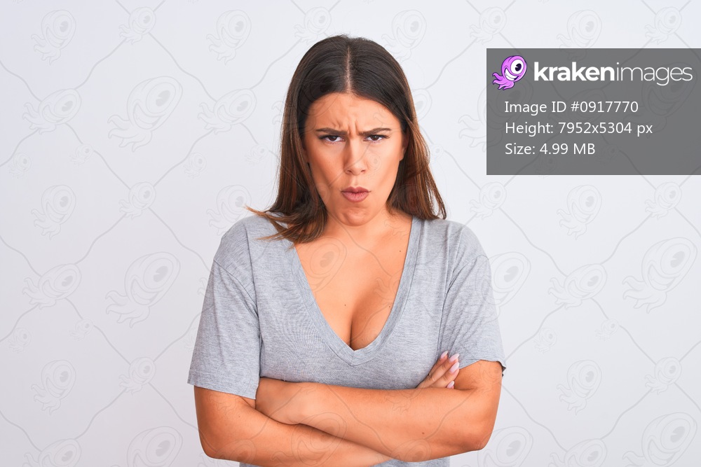 Portrait of beautiful young woman standing over isolated white background skeptic and nervous, disapproving expression on face with crossed arms. Negative person.