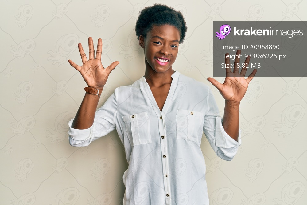 Young african american girl wearing casual clothes showing and pointing up with fingers number ten while smiling confident and happy. 