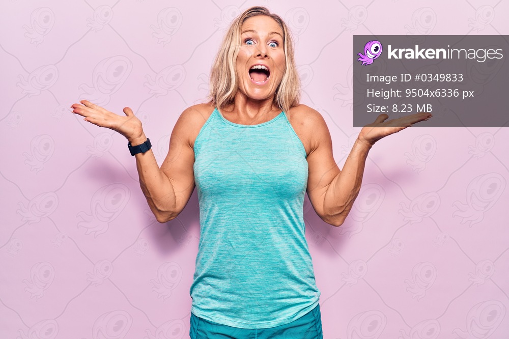 Middle age caucasian blonde woman wearing sports clothes over pink background celebrating crazy and amazed for success with arms raised and open eyes screaming excited. winner concept 