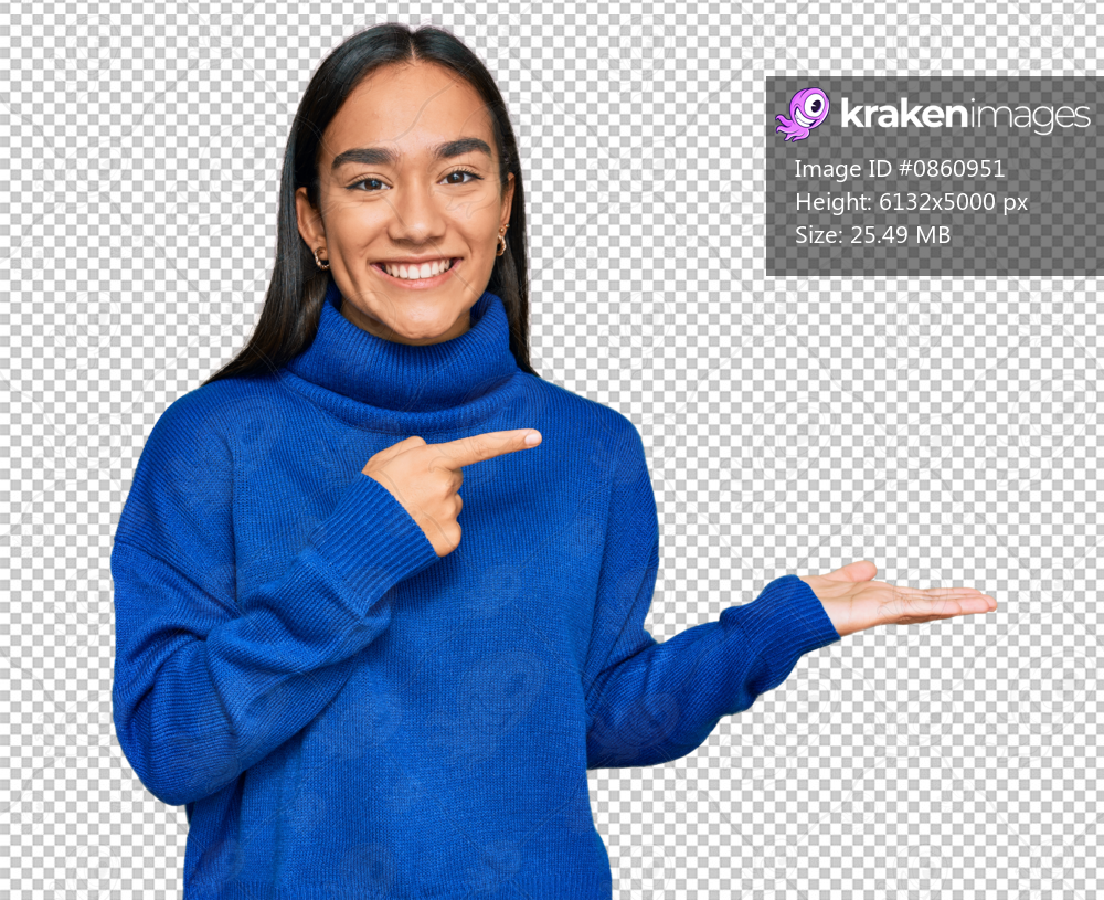 Young asian woman wearing casual winter sweater amazed and smiling to the camera while presenting with hand and pointing with finger.