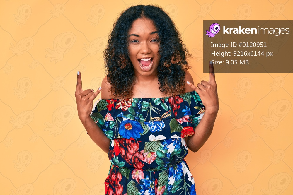 Young african american woman wearing casual clothes shouting with crazy expression doing rock symbol with hands up. music star. heavy concept. 