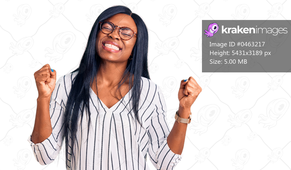 Young african american woman wearing casual clothes and glasses very happy and excited doing winner gesture with arms raised, smiling and screaming for success. celebration concept. 