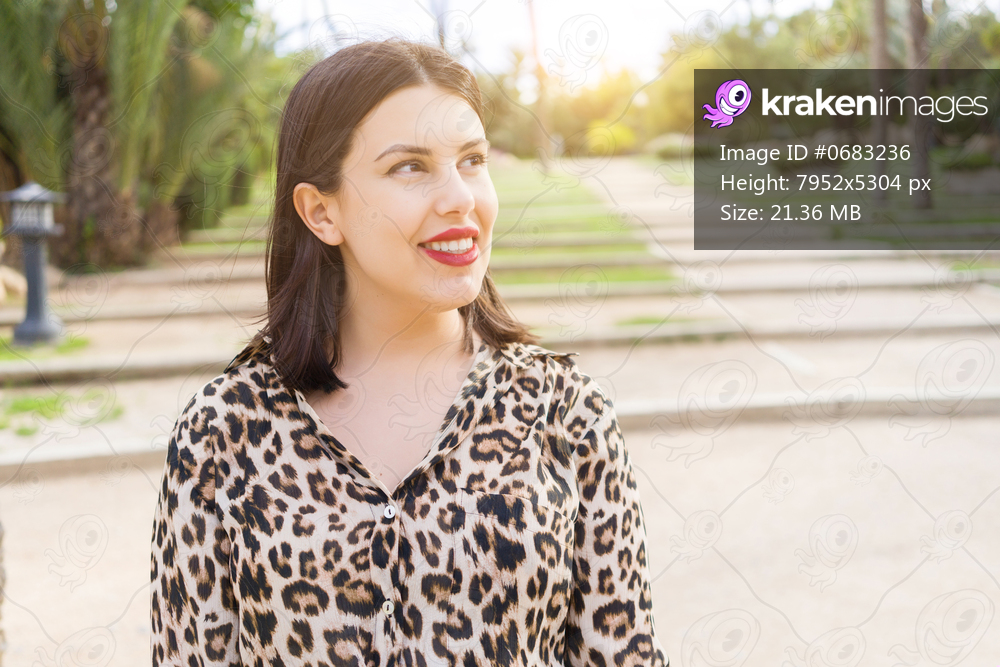 Young beautiful woman with red lips smiling happy at garden