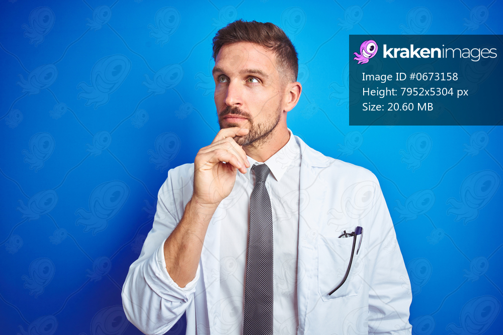 Young handsome doctor man wearing white professional coat over isolated background with hand on chin thinking about question, pensive expression. Smiling with thoughtful face. Doubt concept.