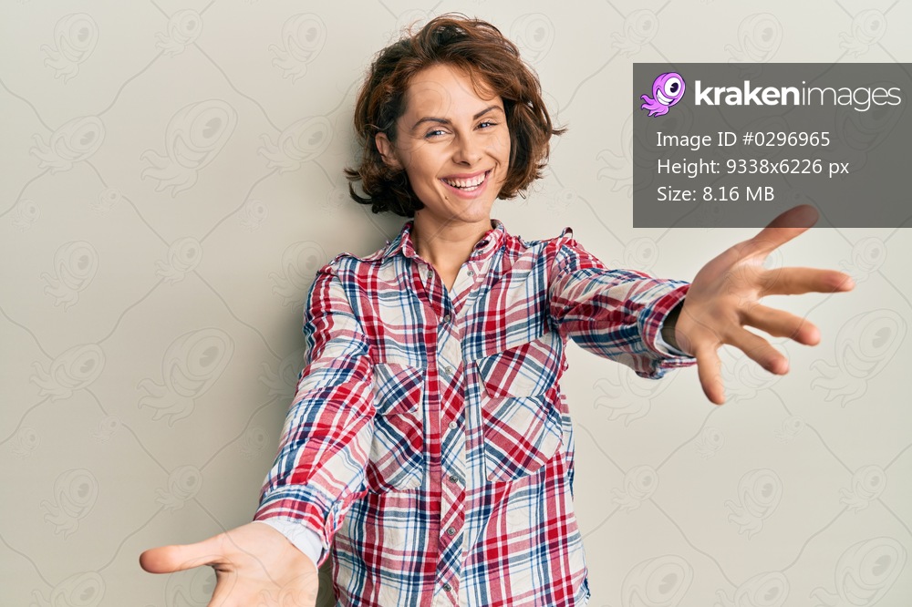 Young brunette woman wearing casual clothes looking at the camera smiling with open arms for hug. cheerful expression embracing happiness. 