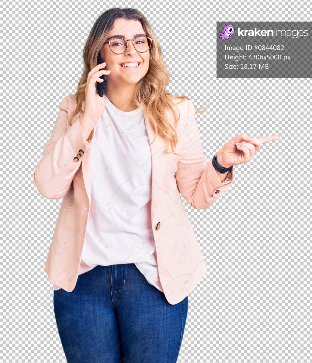 Young caucasian woman having conversation talking on the smartphone smiling happy pointing with hand and finger to the side