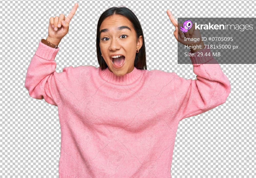 Young asian woman wearing casual winter sweater smiling amazed and surprised and pointing up with fingers and raised arms.