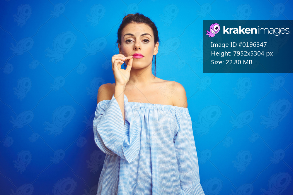 Young beautiful woman wearing bun hairstyle over blue isolated background mouth and lips shut as zip with fingers. Secret and silent, taboo talking