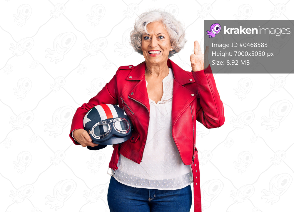Senior grey-haired woman holding motorcycle helmet doing ok sign with fingers, smiling friendly gesturing excellent symbol 