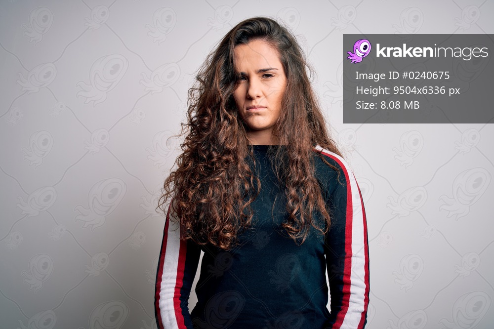 Young beautiful woman with curly hair wearing casual sweater over isolated white background skeptic and nervous, frowning upset because of problem. Negative person.