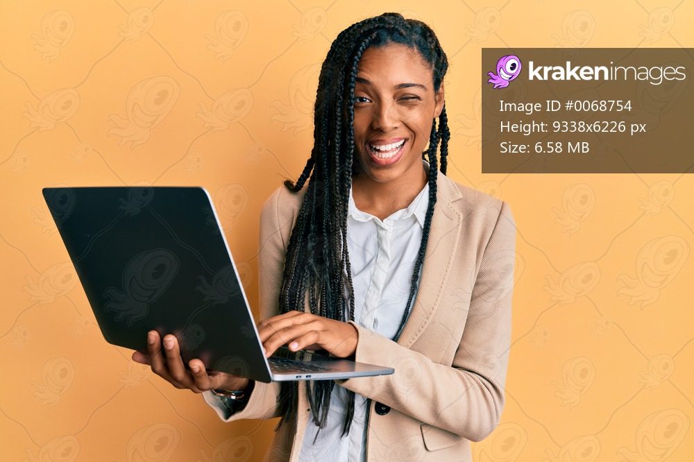 African american woman working using computer laptop winking looking at the camera with sexy expression, cheerful and happy face. 