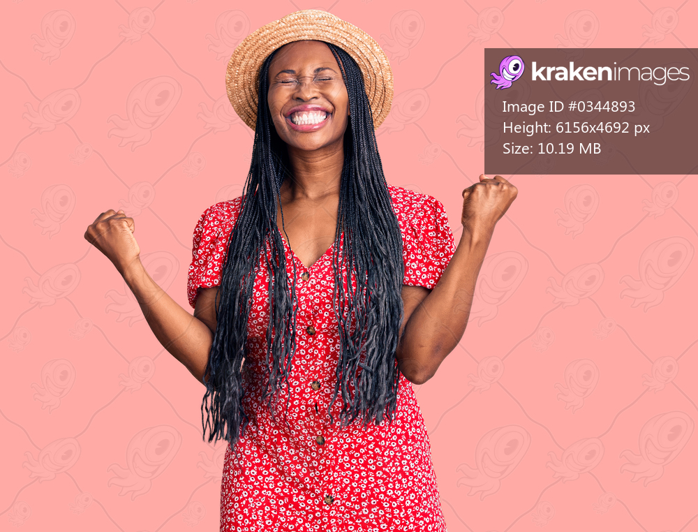 Young african american woman wearing summer hat very happy and excited doing winner gesture with arms raised, smiling and screaming for success. celebration concept. 