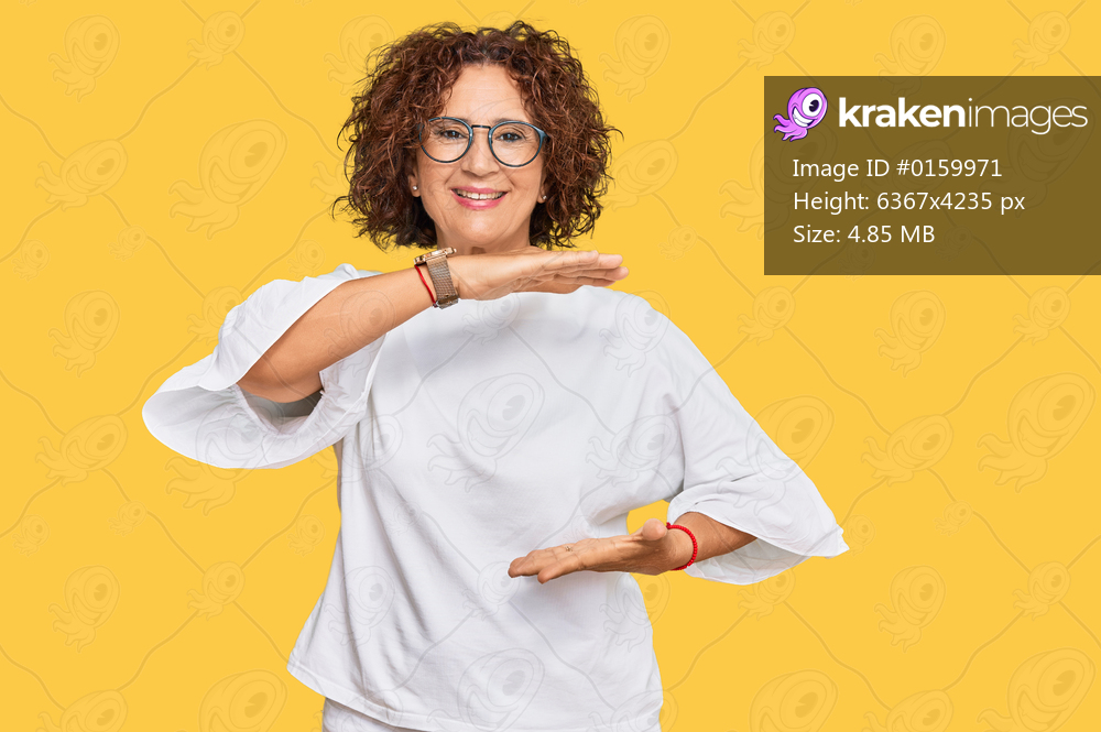 Beautiful middle age mature woman wearing casual clothes and glasses gesturing with hands showing big and large size sign, measure symbol. smiling looking at the camera. measuring concept. 