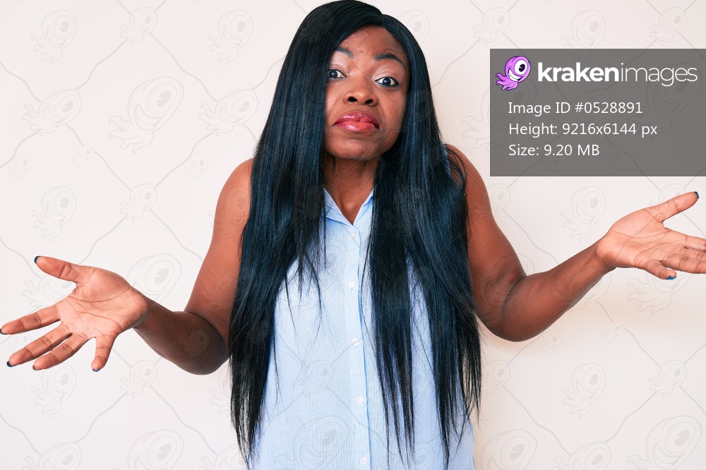 Young african american woman wearing casual clothes clueless and confused expression with arms and hands raised. doubt concept. 